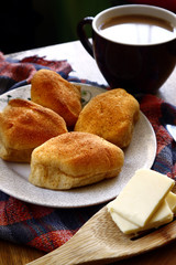 Freshly baked Filipino bread called Pan de sal or Bread of Salt, coffee, slices of cheese on a table