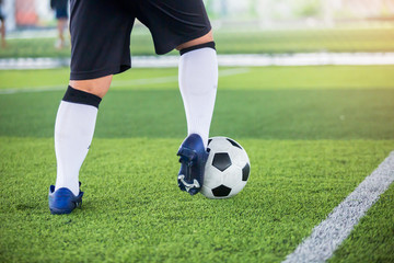 Soccer player control to shoot ball on green artificial turf to goal. Boy soccer player training for match. Football player in football academy.