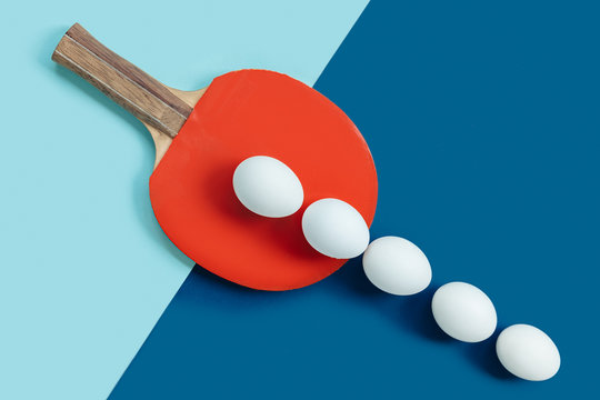 There are white eggs on the red table tennis racket. White eggs lie in a row and go out of bounds. The background of the image is divided into 2 parts by color and textures.