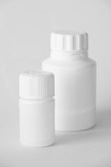 White Plastic Pill Bottles On A Gray Surface