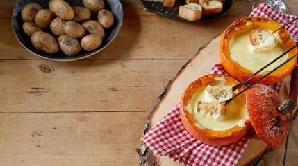 Serving of Swiss cheese fondue in fall pumpkins