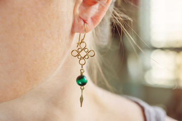 Female ear wearing tiny elegant metal wire stone bead earring