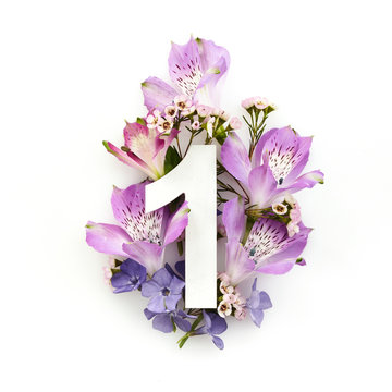 Creative layout with colourful flowers and number one. Flat lay. Top view.