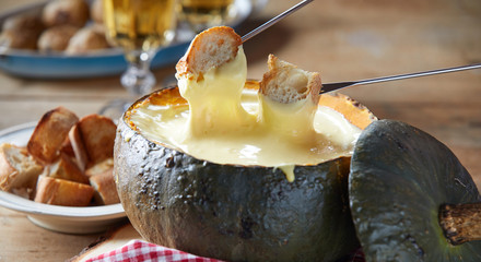 Rustic serving of cheese fondue in a pumpkin rind