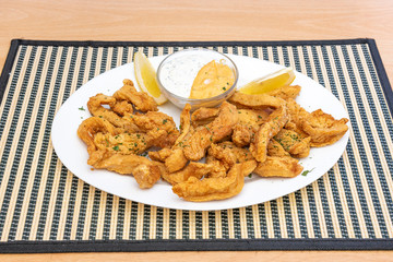 Plate of chicken fingers with sauce