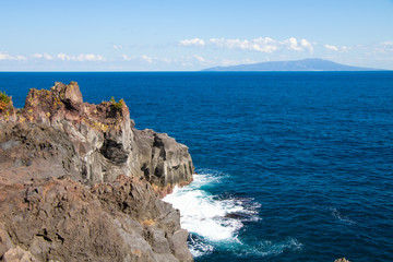 Fototapeta na wymiar Ocean cliff with Izu-oshima island background in Izu peninsula, Shizuoka, Japan