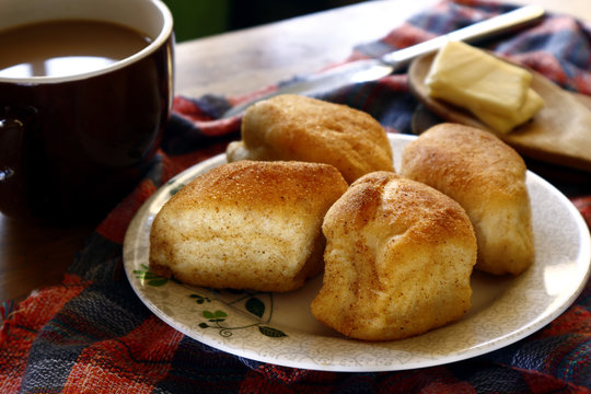 Freshly baked Filipino bread called Pan de sal or Bread of Salt, coffee, slices of cheese on a table
