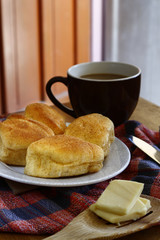 Freshly baked Filipino bread called Pan de sal or Bread of Salt, coffee, slices of cheese on a table