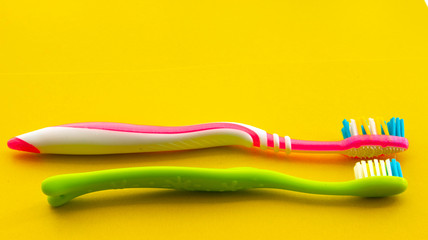 Toothbrushes on a yellow background. Selective focus