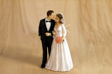 Statuette of the newlyweds for the wedding cake on the wood background