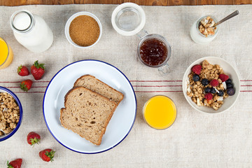 Healthy breakfast with toast, orange juice, cereal, milk, yogurt and strawberries. Copy space