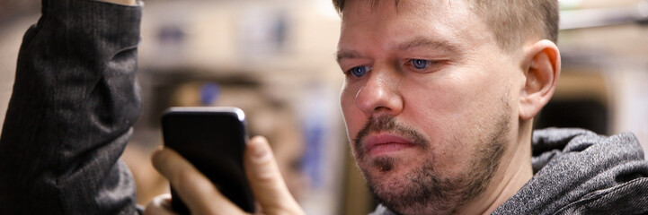 Obraz premium Guy reads from smartphone in public transport