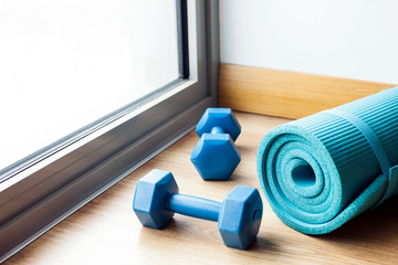 Obraz premium Sport fitness equipment, female concept, yoga mat, bottle of water, dumbbells.