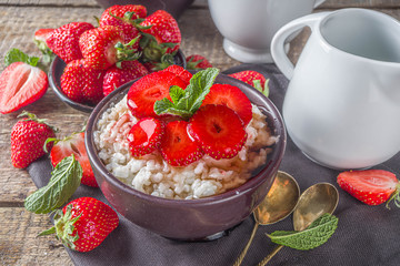 Summer morning rice pudding or rice porridge with strawberry and berry syrup in small bowl for, With milk and fresh strawberry copy space
