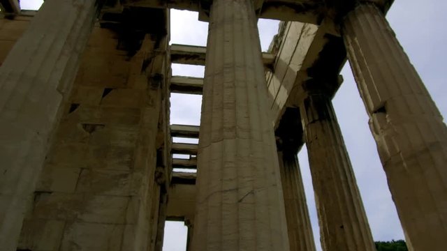 Tilt down and tracking shot camera moves slowly forward in the length of the Temple of Hephaestus in The roman agora of Athens