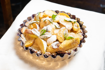 Juicy banana pie. Delicious Thanksgiving apple pie with mint or basil. Baking in the oven. Pie with banana. Sweet cupcake with baked fruit sprinkled with powder.