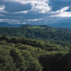 Fototapeta premium view of mountain landscape with clouds and trees in Pyrénées