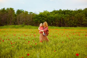 children with mom picking flowers in poppy field