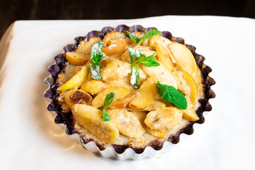 Juicy banana pie. Delicious Thanksgiving apple pie with mint or basil. Baking in the oven. Pie with banana. Sweet cupcake with baked fruit sprinkled with powder.