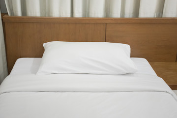 Interior of a hotel bedroom with white bed ,white pillow and white curtain. White bedroom decoration.