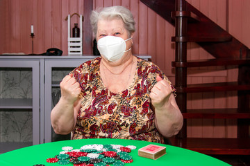 An aged lady in an individual protective mask spends time in the period of self-isolation during a...