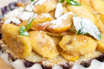 Juicy banana pie. Delicious Thanksgiving apple pie with mint or basil. Baking in the oven. Pie with banana. Sweet cupcake with baked fruit sprinkled with powder.