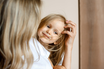 Close-up of a baby girl who is hugging her mom.