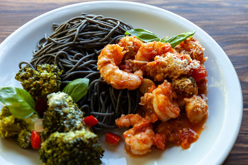 Black spaghetti with shrimp tomato sauce and baked broccoli with Roquefort cheese