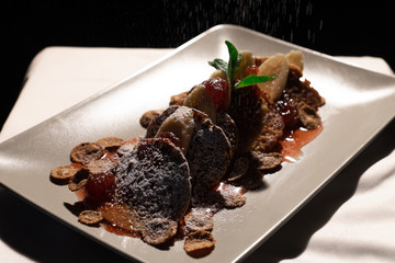 Juicy fritters with fruit for breakfast. Tasty cheesecakes with jam and bananas. Beautiful food from the restaurant cooked by a chef cook. Sweet dessert. A dish of flour and eggs.