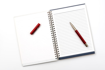 Open notebook with a pen on a white office table