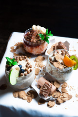 Fresh oatmeal and rice porridge with a beautiful serving and fruit. Bananas, berries, oranges and kiwi. Healthy and nutritious breakfast for children and adults. Different cereals