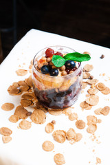 Fresh oatmeal and rice porridge with a beautiful serving and fruit. Bananas, berries, oranges and kiwi. Healthy and nutritious breakfast for children and adults. Different cereals