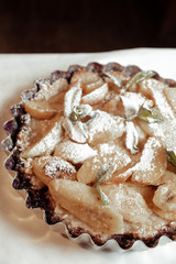 Juicy banana pie. Delicious Thanksgiving apple pie with mint or basil. Baking in the oven. Pie with banana. Sweet cupcake with baked fruit sprinkled with powder.
