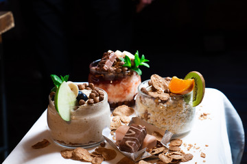 Fresh oatmeal and rice porridge with a beautiful serving and fruit. Bananas, berries, oranges and kiwi. Healthy and nutritious breakfast for children and adults. Different cereals