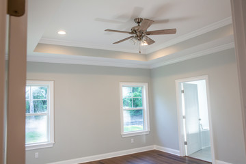 Modern new Construction house master bedroom with Tray ceiling and hardwood floors