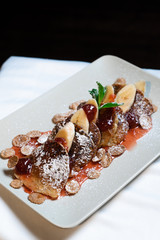 Juicy fritters with fruit for breakfast. Tasty cheesecakes with jam and bananas. Beautiful food from the restaurant cooked by a chef cook. Sweet dessert. A dish of flour and eggs.
