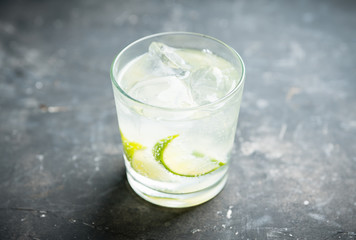 Rum based cocktail caipirinha (variation of cuba libre) on the rustic background. Selective focus. Shallow depth of field.