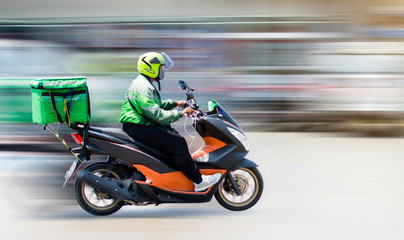 Food delivery staff drive motorbikes and rush to deliver food to customers who order food online. Due to the impact of the virus spread, most people live in Ban Nonthaburi, Thailand on 22/04/2020. © wittaya