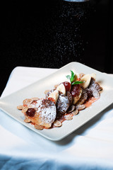Juicy fritters with fruit for breakfast. Tasty cheesecakes with jam and bananas. Beautiful food from the restaurant cooked by a chef cook. Sweet dessert. A dish of flour and eggs.