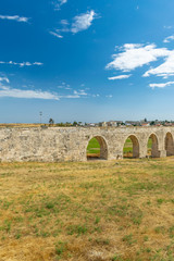 Fototapeta na wymiar The picturesque ancient aqueduct is located near the city of Larnaca.
