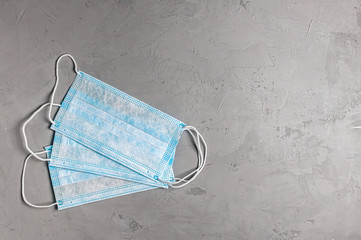 blue disposable mask on a grey concrete background