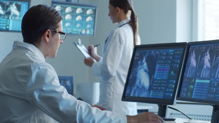 Medical doctors working in hospital office making computer research. Medicine, healthcare and technology concept. - Powered by Adobe