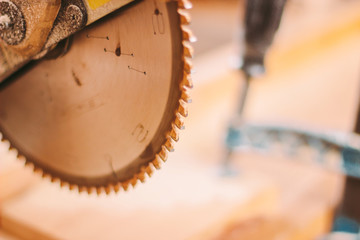 Closeup of professional sawing machine for cutting wooden boards at sawmill. Sharp metal blade of electrical circular saw at wood furniture production factory. Cutting tool for carpenter workshop