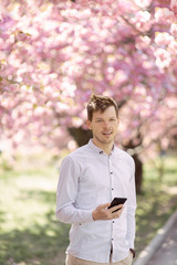 guy in a white shirt in sakura trees