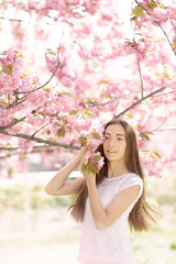 Obraz na płótnie Canvas beautiful bright girl in saturated sakura