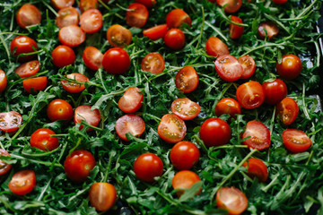 fresh small tomatoes on fresh arugula leaves