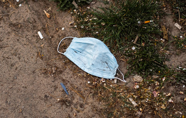 Stop Covid 19. The end of coronavirus. People discard surgical protective face mask on a public streets. Dirty used medical mask laying on the ground during an epidemic. Risk of disease, spread of