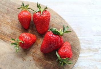 Red fresh strawberries lie on a wooden Board. The concept of fresh and healthy food. The concept of delivering fresh fruit and berries home.