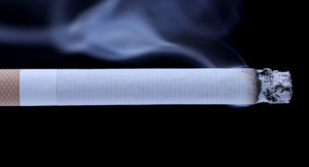 Smoldering cigarette on a black background