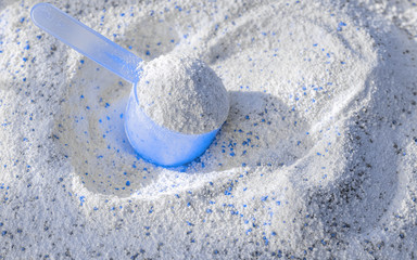 Detergent shirt. Soap white texture with scoop. Liquid powder in cup for washing machine. Laundry wash clothes background. Eco style cleaning concept.